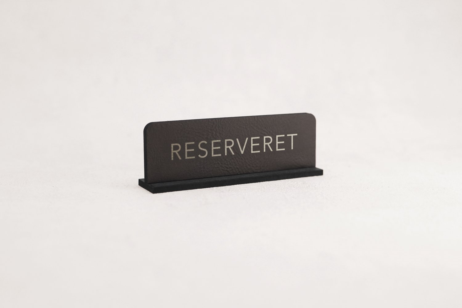 Små reservationskilte i læder til restaurant med sølvskrift