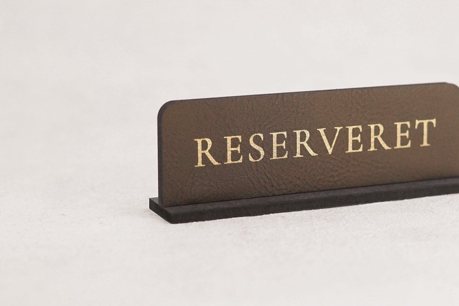 Små reservationskilte i læder til restaurant med guldskrift