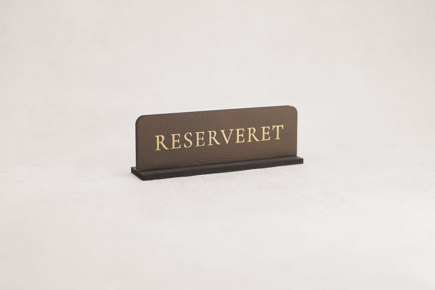 Små reservationskilte i læder til restaurant med guldskrift
