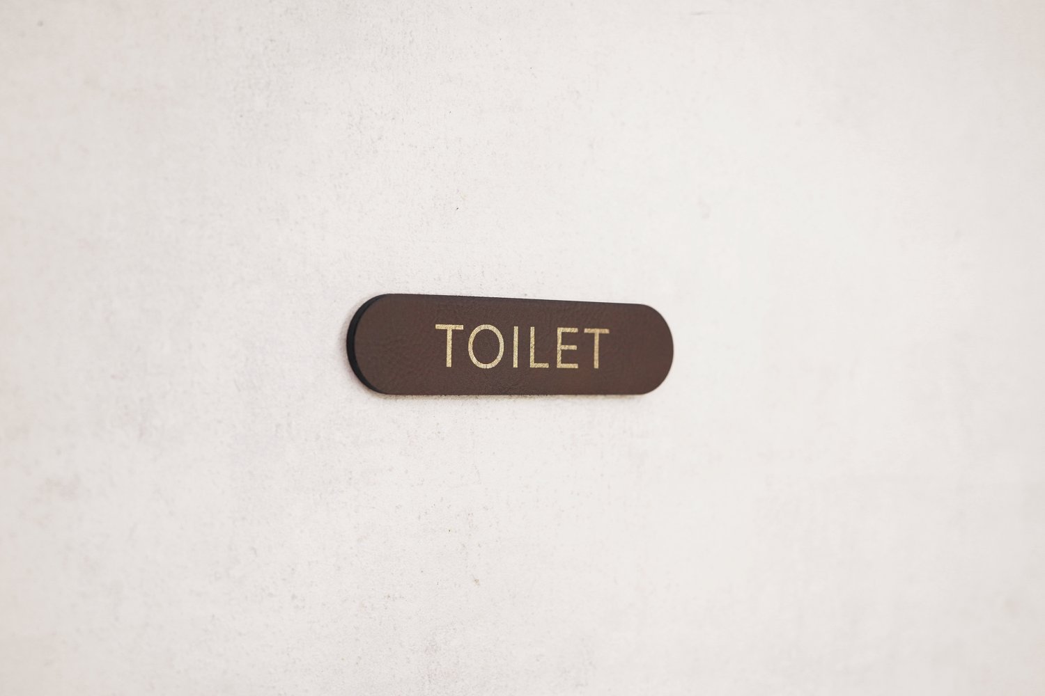 Toiletskilte i læder med guldskrift